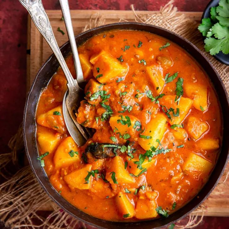 Spicy Aloo Tamatar Sabzi served in a bowl with fresh coriander garnish – a simple Indian potato tomato curry