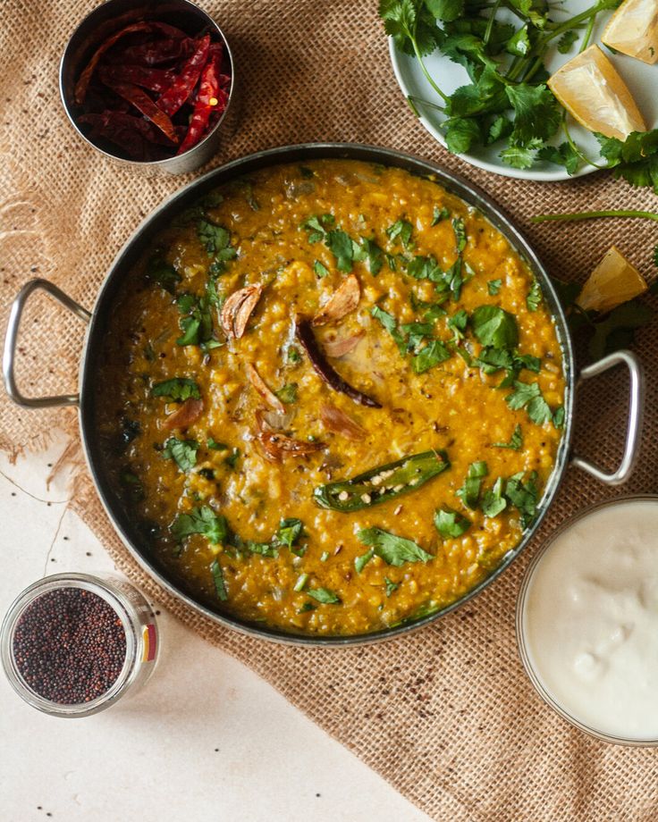 Masoor dal tadka with garlic tempering, garnished with fresh coriander – traditional red lentil curry served in a steel kadhai
